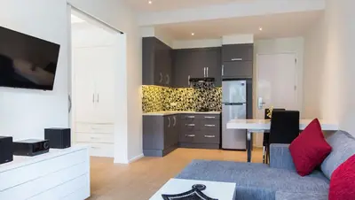 a living room with a couch and a kitchen at Coast Boutique Hotel in Kuta