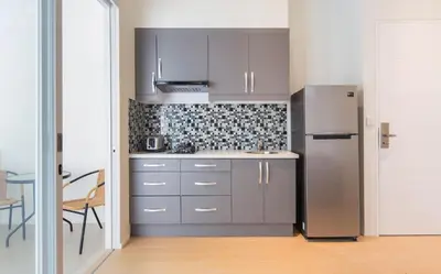 a kitchen with a stainless steel refrigerator and a table at Coast Boutique Hotel in Kuta