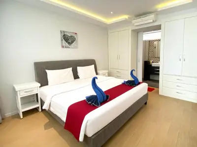 a bedroom with a large bed with blue tufty pillows at Coast Boutique Hotel in Kuta