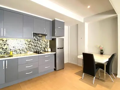 a kitchen with gray cabinets and a table with chairs at Coast Boutique Hotel in Kuta