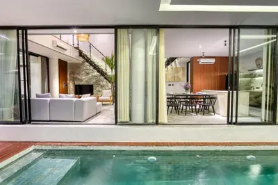 a house with a swimming pool and a living room at Modern 4BR Industrial - Tropical Escape in Umalas in Kerobokan