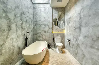 a bathroom with a white tub and a toilet at Modern 4BR Industrial - Tropical Escape in Umalas in Kerobokan