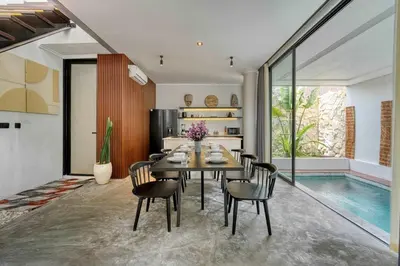 a dining room with a table and chairs and a pool at Modern 4BR Industrial - Tropical Escape in Umalas in Kerobokan