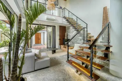 a living room with a spiral staircase and a couch at Modern 4BR Industrial - Tropical Escape in Umalas in Kerobokan