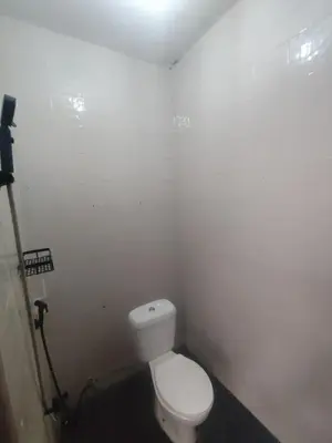 a bathroom with a white toilet in a room at The Fatul Villa in Ngurah Rai International Airport