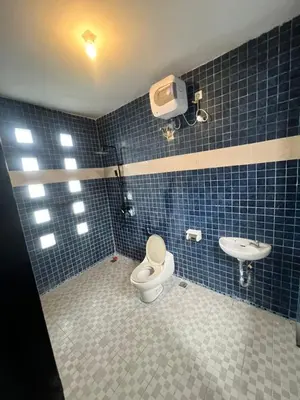 a blue tiled bathroom with a toilet and a sink at The Fatul Villa in Ngurah Rai International Airport