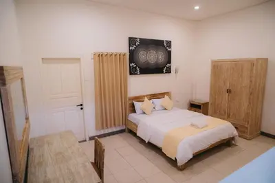a bedroom with a bed and a table and a door at Adijaya Room 1 in Seminyak