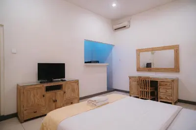 a bedroom with a bed and a television on a cabinet at Adijaya Room 1 in Seminyak