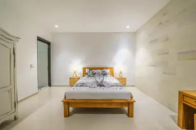 a bedroom with a bed and two lamps on the sides at Villa Kusuma 2 Seminyak in Seminyak