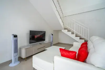 a living room with a white couch with red pillows at Luxury minimalist villa The Toy in Kerobokan