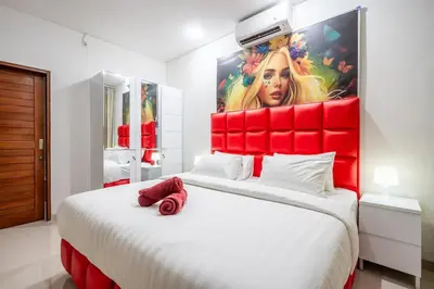 a bedroom with a large bed with a red headboard at Luxury minimalist villa The Toy in Kerobokan