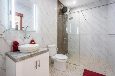 a bathroom with a toilet and a sink and a shower at Luxury minimalist villa The Toy in Kerobokan