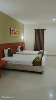 two beds in a hotel room with at Puri dibia apartment in Kuta