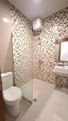 a bathroom with a toilet and a glass shower at Mahesa Seminyak in Seminyak