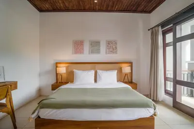 a bedroom with a large bed and a window at Villa Aura by Maheswara in Seminyak