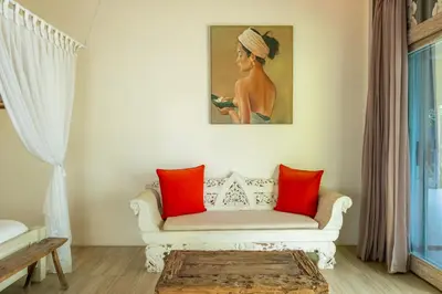 a living room with a white couch with red pillows at Luxury Aliya Villa by Betterplace in Sanur