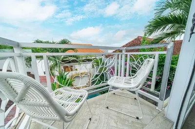 a pair of chairs sitting on a balcony at Villa 888 Tropical Heart - 1BR Pool Villa Seminyak in Seminyak