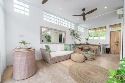 a living room with a couch and a mirror at Villa 888 Tropical Heart - 1BR Pool Villa Seminyak in Seminyak