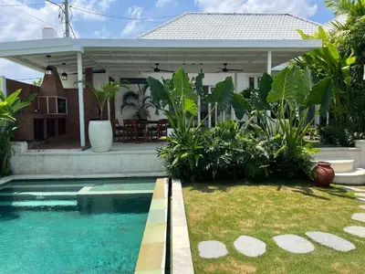 a house with a swimming pool in front of a house at 3BR Luxury Retreat Umalas with Pool - Villa Theo in Canggu