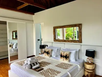 a bedroom with a large white bed with a mirror at 3BR Luxury Retreat Umalas with Pool - Villa Theo in Canggu