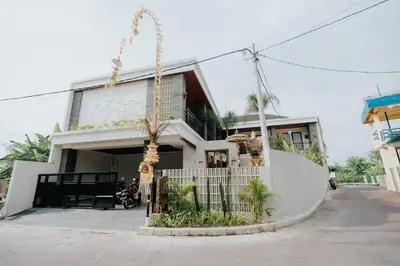 a building with a palm tree in front of it at Casa Nika Suites Seminyak in Seminyak