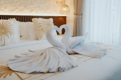 two white swans sitting on top of a bed at Casa Nika Suites Seminyak in Seminyak