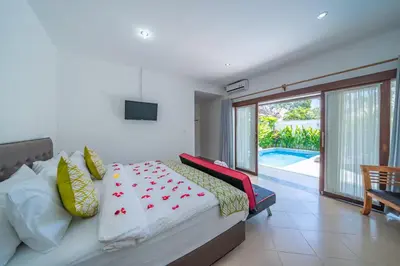 a bedroom with a bed and a view of a pool at Villa Dream Seminyak in Seminyak