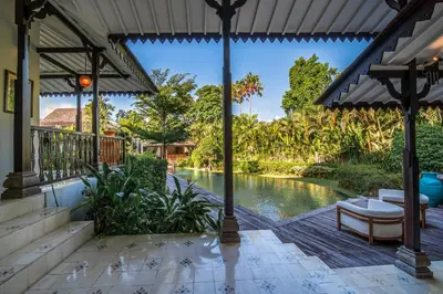 an outdoor patio with a pool in front of a house at Villa Yumi by BaliSuperHost in Canggu