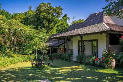 a house with a table and chairs in a yard at Villa Yumi by BaliSuperHost in Canggu