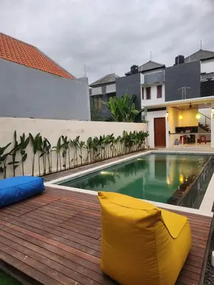 a yellow chair sitting on a deck next to a swimming pool at Bali Thousand Island in Pesanggaran