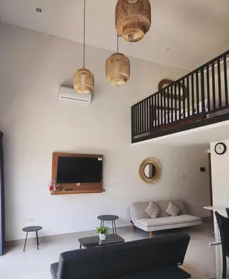 a living room with a couch and a tv on the wall at Bali Thousand Island in Pesanggaran
