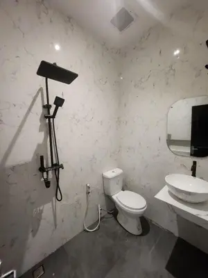 a bathroom with a white toilet and a sink at Bali Thousand Island in Pesanggaran