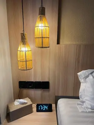 a bedroom with two lights and a clock on a bed at Summerville Homes in Canggu