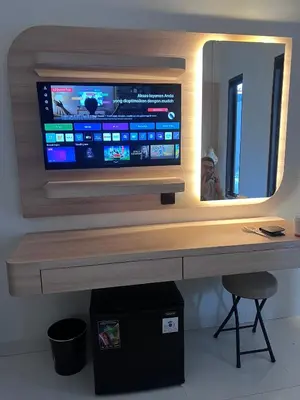 a desk with a television on a wall with a mirror at Summerville Homes in Canggu