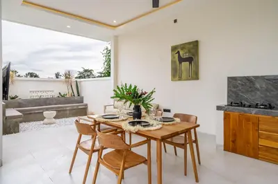 a dining room with a wooden table and chairs at Dasha 2- Chic 2BR in Canggu in Canggu