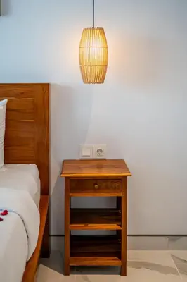 a bedroom with a bed and a table with a lamp at Villa Lotus Seminyak in Seminyak
