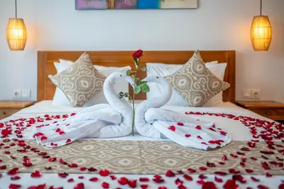 two swansuitsrendered to look like they are sitting on a bed at Villa Lotus Seminyak in Seminyak