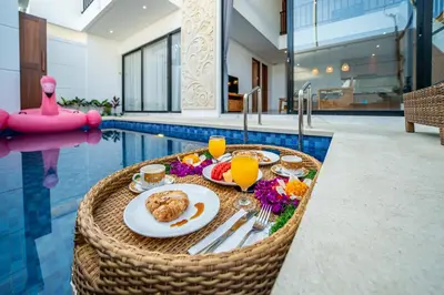 a breakfast table with food and drinks in a swimming pool at Villa Lotus Seminyak in Seminyak