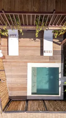 a building with a swimming pool on a wooden deck at New Villa Uluwatu 1BR 1K with Private pool in Jimbaran