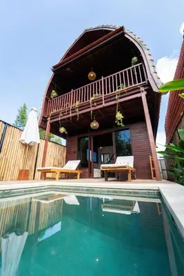 a house with a swimming pool in front of it at Pura Villa in Uluwatu in Jimbaran