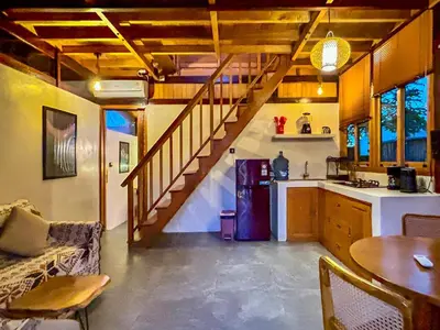 a kitchen with a staircase leading up to a living room at Makaha Bungalow in Jimbaran