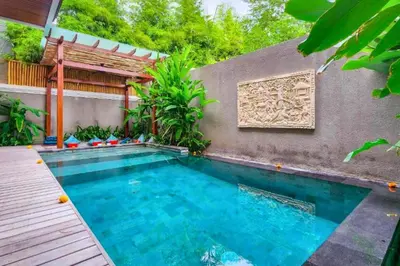 a swimming pool in front of a house at Belisaria Comfortable 3 BR Private Pool Villa in Sanur