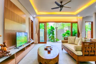 a living room with a couch and a tv at Belisaria Comfortable 3 BR Private Pool Villa in Sanur