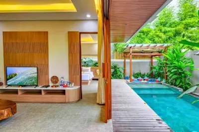 a house with a swimming pool and a living room at Belisaria Comfortable 3 BR Private Pool Villa in Sanur