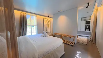 a bedroom with a white bed and a window at Naiika villa in Seminyak