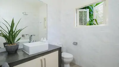 a white bathroom with a sink and a toilet at Villa Merta Sari 8 by Villa Finder in Seminyak