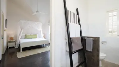 a white bedroom with a bed and a toilet at Villa Merta Sari 8 by Villa Finder in Seminyak