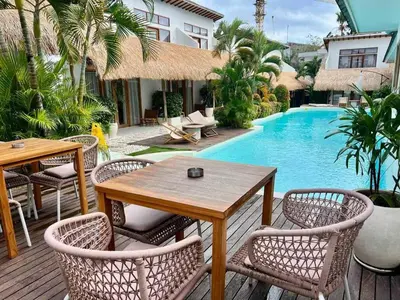 a wooden deck with a table and chairs next to a pool at 1BR Tropical Villa With Pool - Canggu - Berawa in Canggu