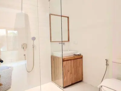 a bathroom with a sink and a shower with a mirror at 1BR Tropical Villa With Pool - Canggu - Berawa in Canggu