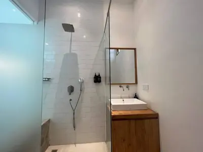 a bathroom with a shower and a sink and a mirror at 1BR Tropical Villa With Pool - Canggu - Berawa in Canggu